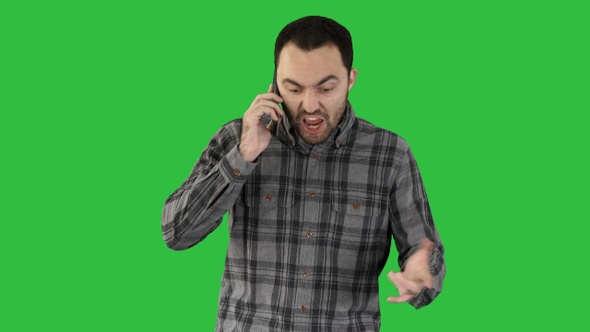 Man angry talking on telephone and walking on a Green Screen