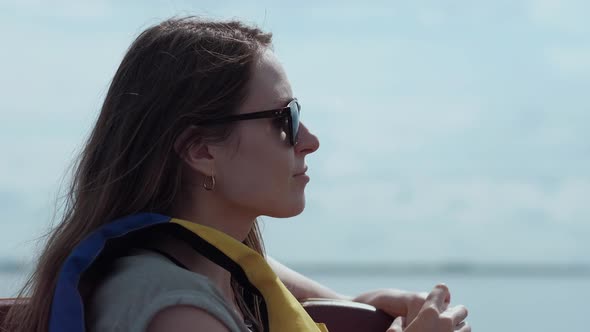 Attractive Brunette in Sunglasses Looking Into the Distance Enjoying the Sea View