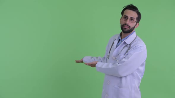 Stressed Young Bearded Persian Man Doctor Showing To Back