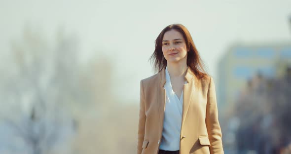 Elegantly Dressed Young Woman Walking Down the Street