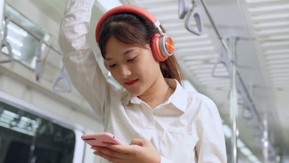 Young Woman Using Mobile Phone on Public Train