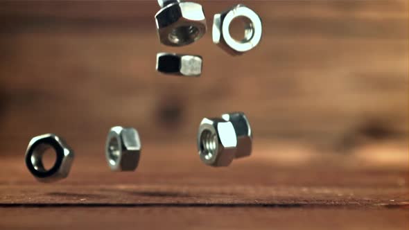 Metal Nuts Fall on the Wooden Table