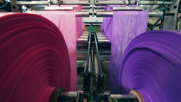 Reels with Polyethylene Wrapping Paper Rolling Through Them. Polyethylene Production Factory