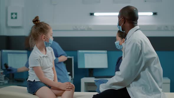 Physician and Nurse Giving Bottle of Pills to Sick Kid at Consultation