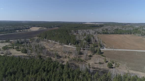 Aerial view of small river between the forest and the field