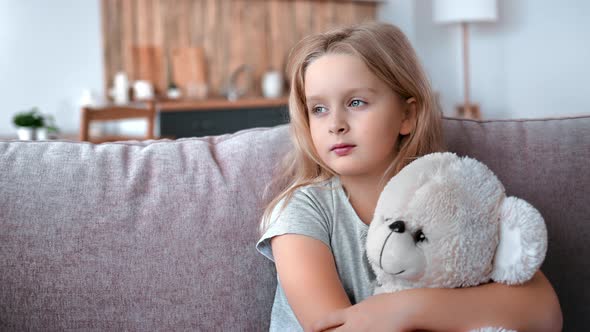 Closeup Pensive Little Cute Girl Hugging Teddy Bear at Home Suffering Loneliness Lost Parents