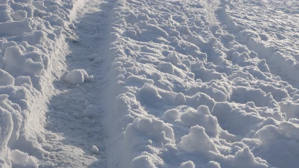 Vehicle tires traces in the snow slow tilt 4K 2160p 30fps UltraHD footage - Tilting over snow dunes 