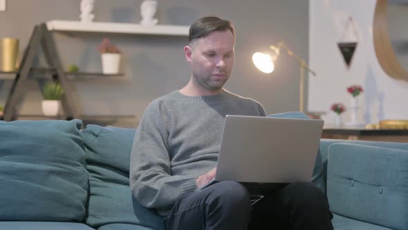 Casual ManWorking on Laptop on Sofa