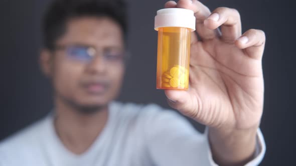 Young Man Hand Holding Medicine Pill Container