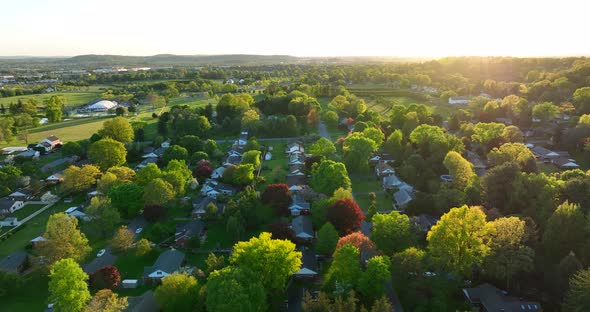 High aerial descending shot of sprawling neighborhood. Small town America during beautiful spring su