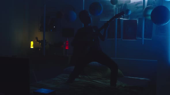 Teenager Having Rock Concert in Bedroom