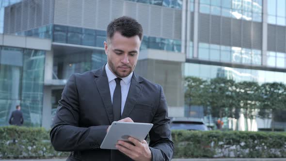 Businessman Using Tablet for Browsing Standing Outside Office