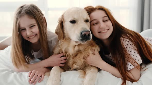 Girls with Golden Retriever Dog in the Bed