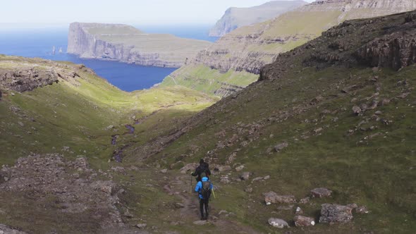 Adventurers Hiking Down Beautiful Mountain Trail in Tjornuvik Faroe Islands