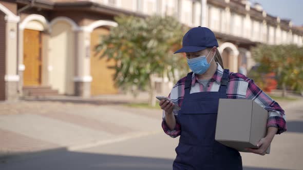 Delivery Woman Using Mobile App on Phone Outdoors