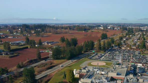 Fast Drone Orbits a Hospital Helipad by a Busy Highway on a Sunny Day