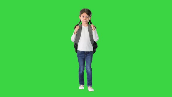 Smiling Little Girl Walking To School with a Backpack on a Green Screen, Chroma Key
