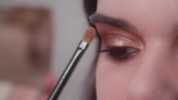 Professional Makeup Artist Doing Smoky Eyes Effect with Liner and Eye Shadow