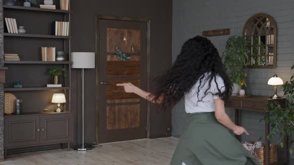 Crazy Active Young Woman Dancing in Room Performs Funny Move Enthusiastic Girl with Long Curly Hair