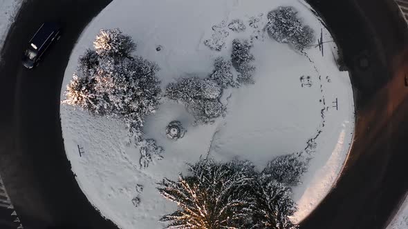 Rising from snow covered inner circle of roundabout in winter time, aerial