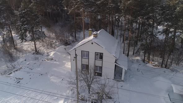 Drone shot of new white modern residential house at winter near the forest 09