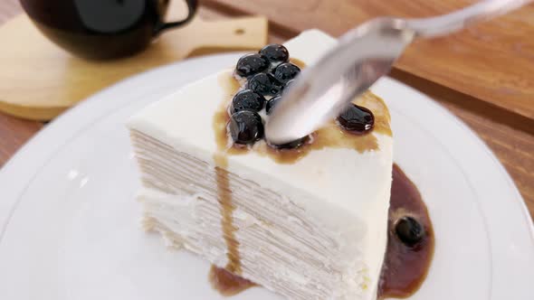 Closeup of a Man with a Teaspoon Breaks Off a Piece of Salty White Cake with Berries