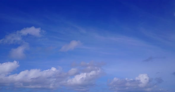 Tropical flying tourism shot of a white sand paradise beach and blue water background in vibrant 4K