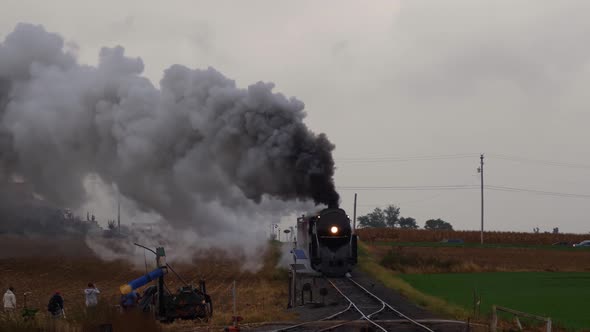 Steam Locomotive Pulling Freight Pulling into Yard with Smoke and Steam