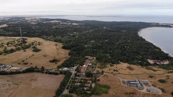 Aerial view of the coastline of Sejerøbugten with hills, fields and ocean.