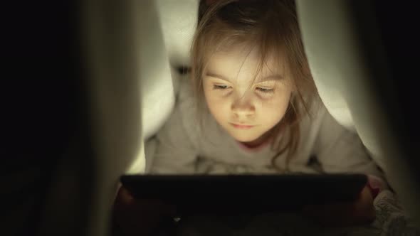 Girl Watching Film on Tablet at Night