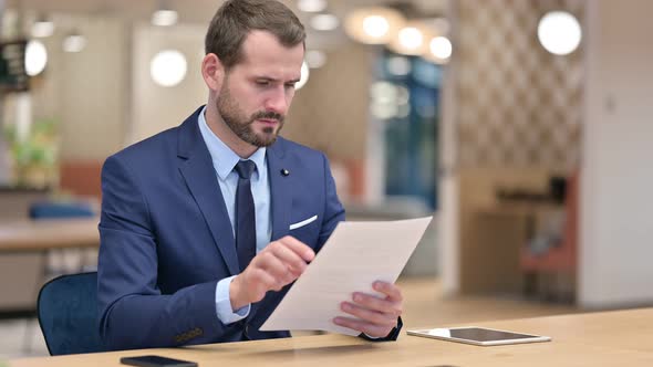 Businessman Working Reading Documents in Office 