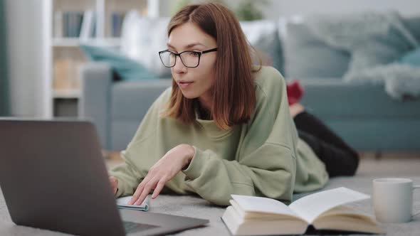 Pleasant Woman Using Laptop for Studying at Home