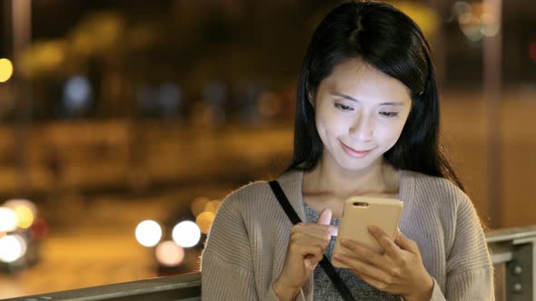 Woman using cellphone at night 