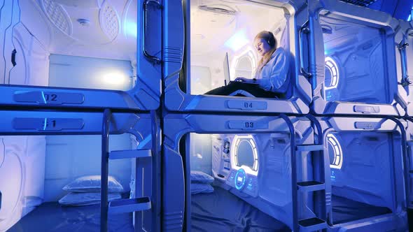 Capsule Hotel with a Girl Listening to Music in One of the Boxes