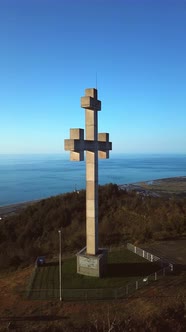drone view flies around stone or concrete cross high in mountains