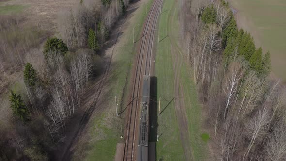 Passenger Train Going Through Spring Fields and Forest Aerial View