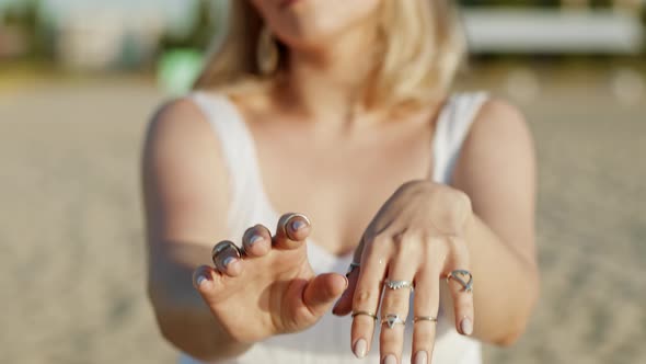 Beautiful Young Gypsy Woman Demonstrates with Hands Dance Boho Jewelry. Girl in White Dress Showing