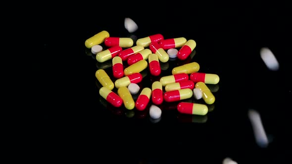 Closeup of Many White Pills Falling on Black Table