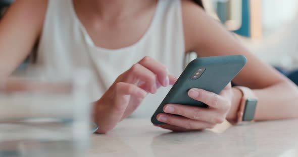 Woman touch on cellphone in restaurant