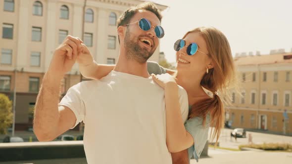 Portrait of smiling beautiful female and her handsome boyfriend posing outdoors