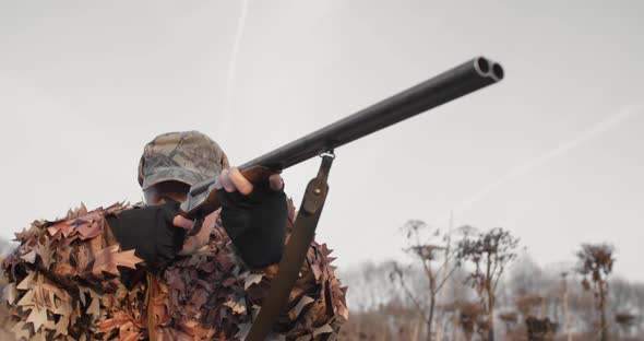 Hunter Aims the Target With Rifle in the Field at Sunny Autumn Evening