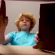 Blonde boy opens a package and is happy about the gift inside. - VideoHive Item for Sale