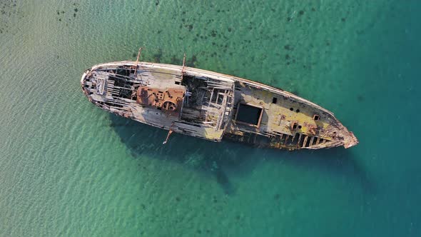 A Wrecked Wooden Ship Lies on the Seashore Covered with Rust