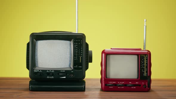Small Old Televisions with Grey Interference Screen on Yellow Background