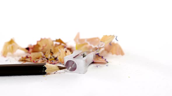 Colored shavings with brown color pencil and sharpener in saucer