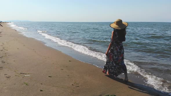 A Lady Walking on a Vast Long Beach