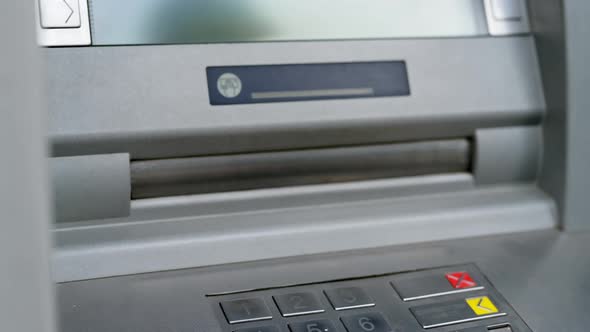 A woman's hand takes money from an ATM. Cash withdrawal, currency concept.