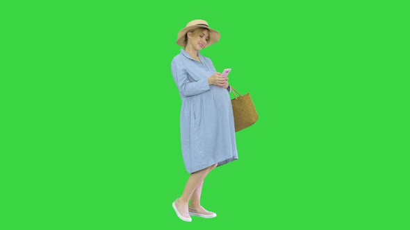 Pregnant Woman on the 9Th Month Using a Smartphone on a Green Screen Chroma Key