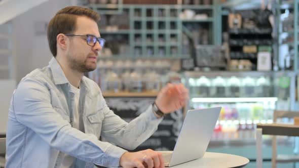 Man Feeling Shocked While Working on Laptop