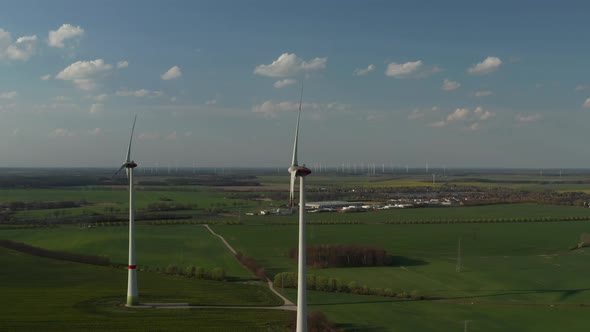 AERIAL: View of Windmills Farm for Energy Production on Beautiful Blue Sky Day with Clouds. Wind